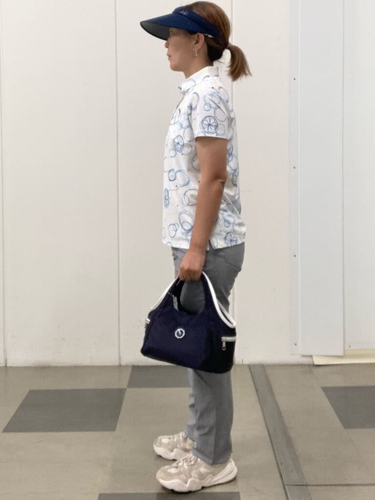 ブルー系のポロシャツ、ホワイト系のその他パンツ、ブルー系のショルダーバッグを着用したレディースの春コーディネートの2枚目の写真