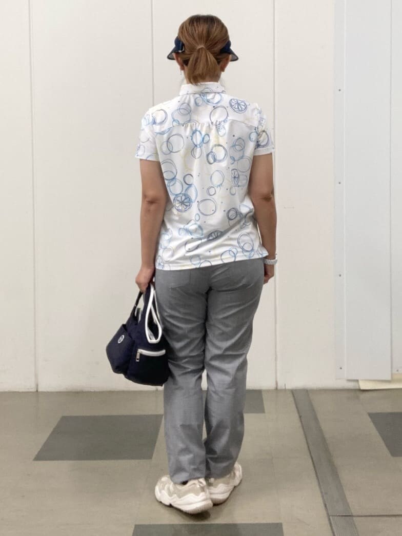 ブルー系のポロシャツ、ホワイト系のその他パンツ、ブルー系のショルダーバッグを着用したレディースの春コーディネートの3枚目の写真