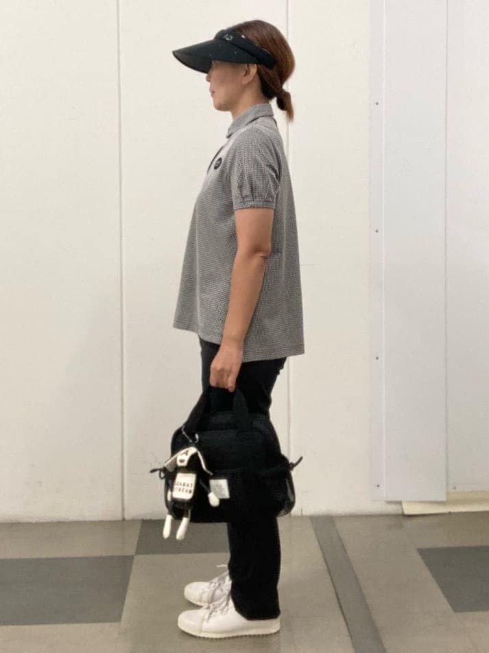 ブラック系のポロシャツ、ブラック系のその他パンツ、ブラック系のハンドバッグを着用したレディースの夏コーディネートの2枚目の写真