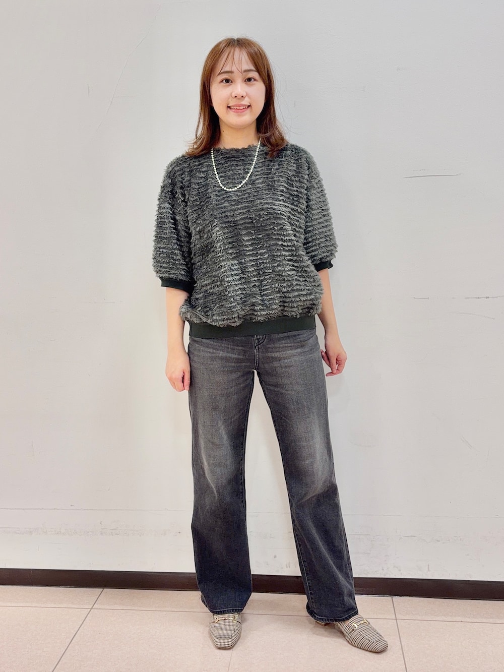 グリーン系のTシャツ/カットソー、ブラック系のデニムパンツを着用したレディースの秋コーディネートの5枚目の写真