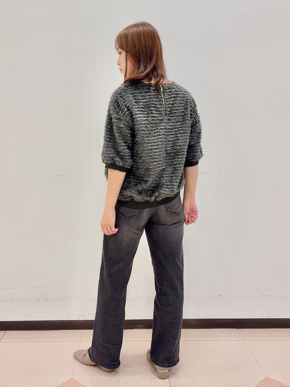 グリーン系のTシャツ/カットソー、ブラック系のデニムパンツを着用したレディースの秋コーディネートの3枚目の写真