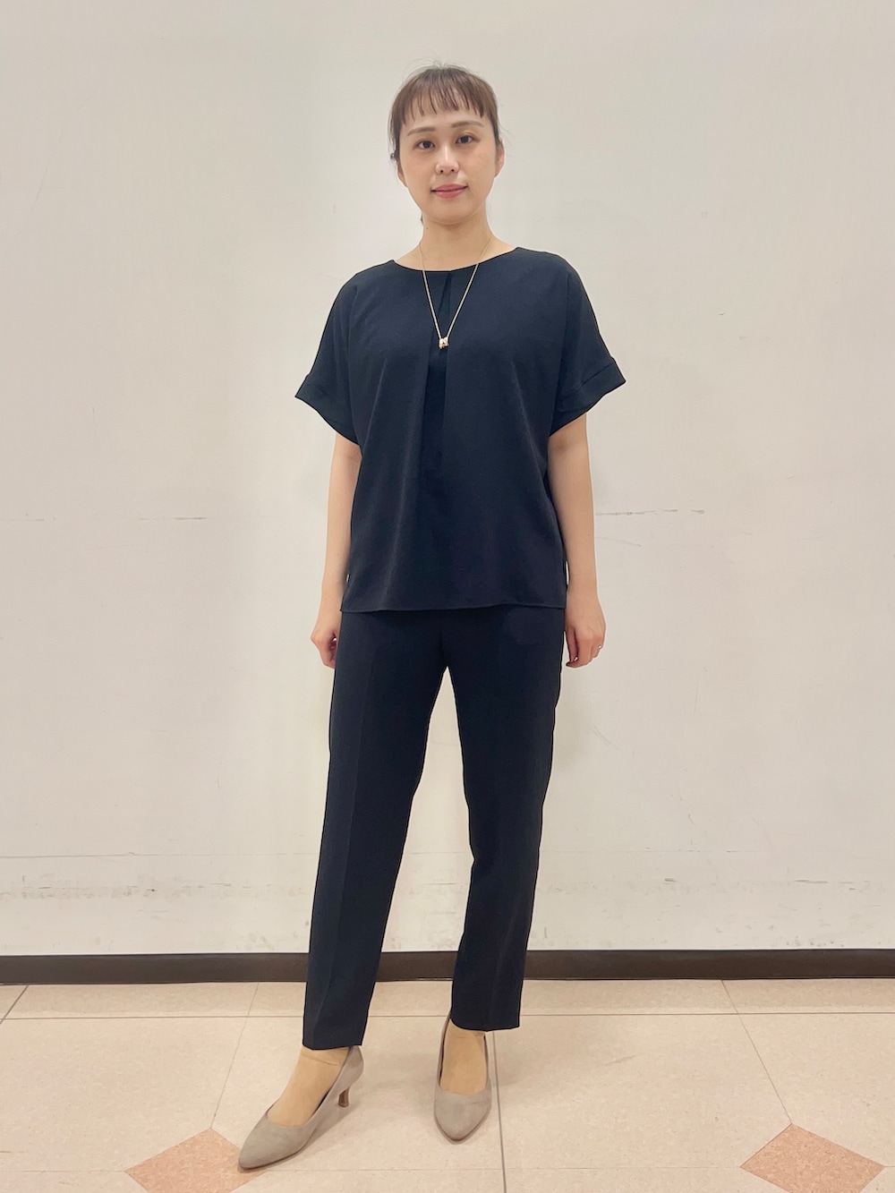 ベージュ系のトートバッグ、ブラック系のワンピース、ブルー系のその他パンツを着用したレディースの春コーディネートの3枚目の写真