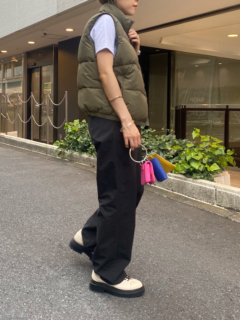 ブラック系のスラックス、イエロー系のショルダーバッグ、グレー系のTシャツ/カットソーを着用したレディースの夏コーディネートの2枚目の写真