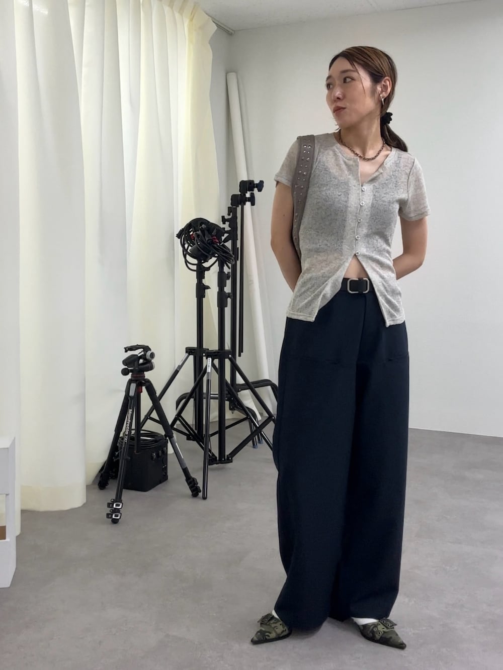 ブルー系のスラックス、グレー系のカーディガン/ボレロ、グリーン系のパンプスを着用したレディースの夏コーディネートの2枚目の写真