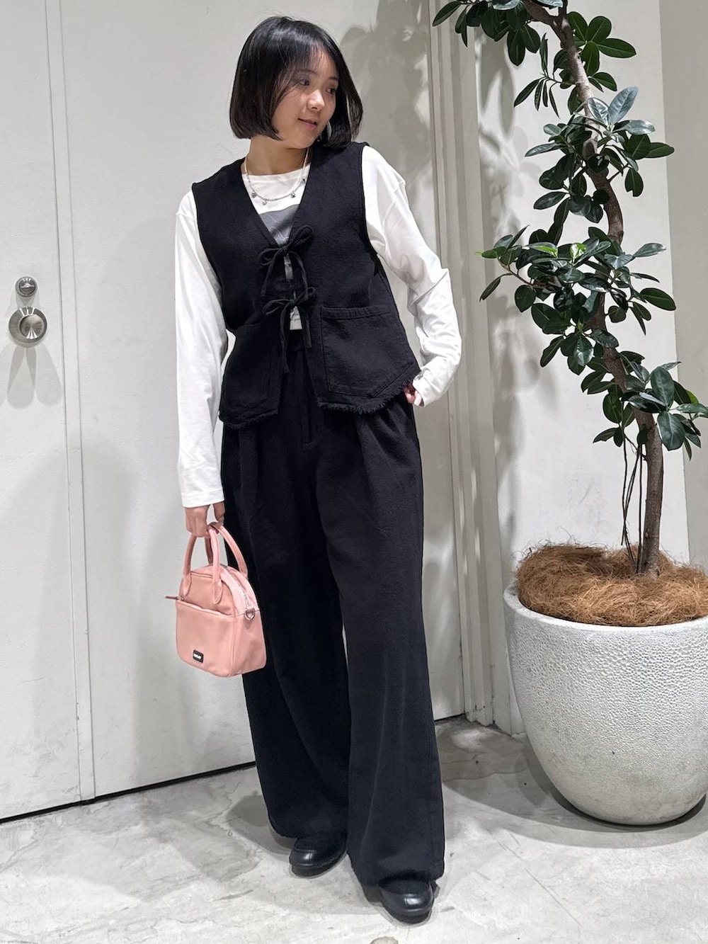 ホワイト系のTシャツ/カットソー、ピンク系のハンドバッグ、ブラック系のバレエシューズを着用したレディースの春コーディネートの3枚目の写真