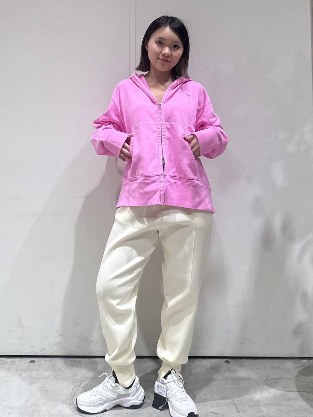 ピンク系のパーカー、ホワイト系のその他パンツを着用したレディースの冬コーディネートの4枚目の写真