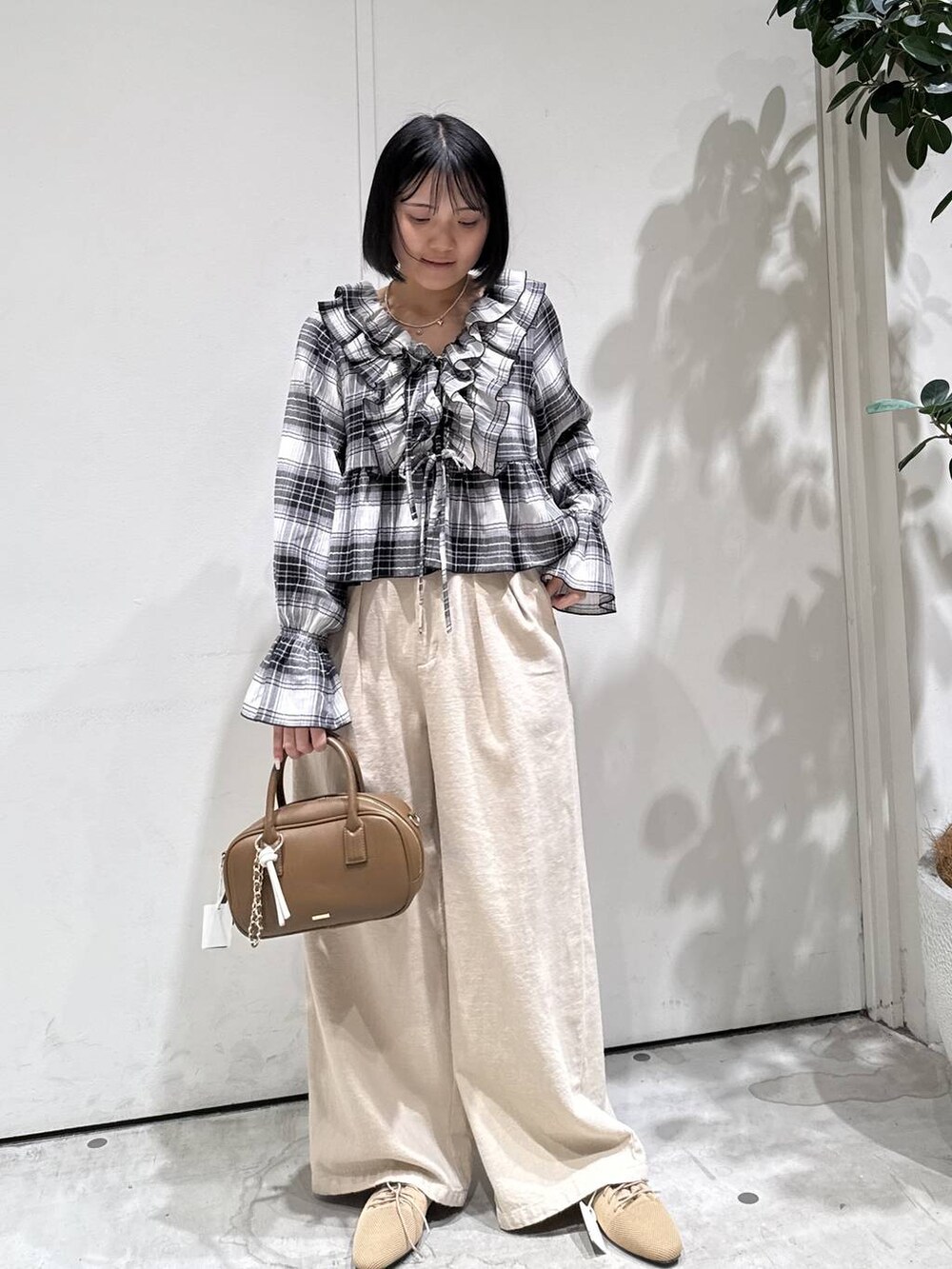 ブラウン系のハンドバッグ、ベージュ系のサンダル、ベージュ系のその他パンツを着用したレディースの春コーディネートの3枚目の写真
