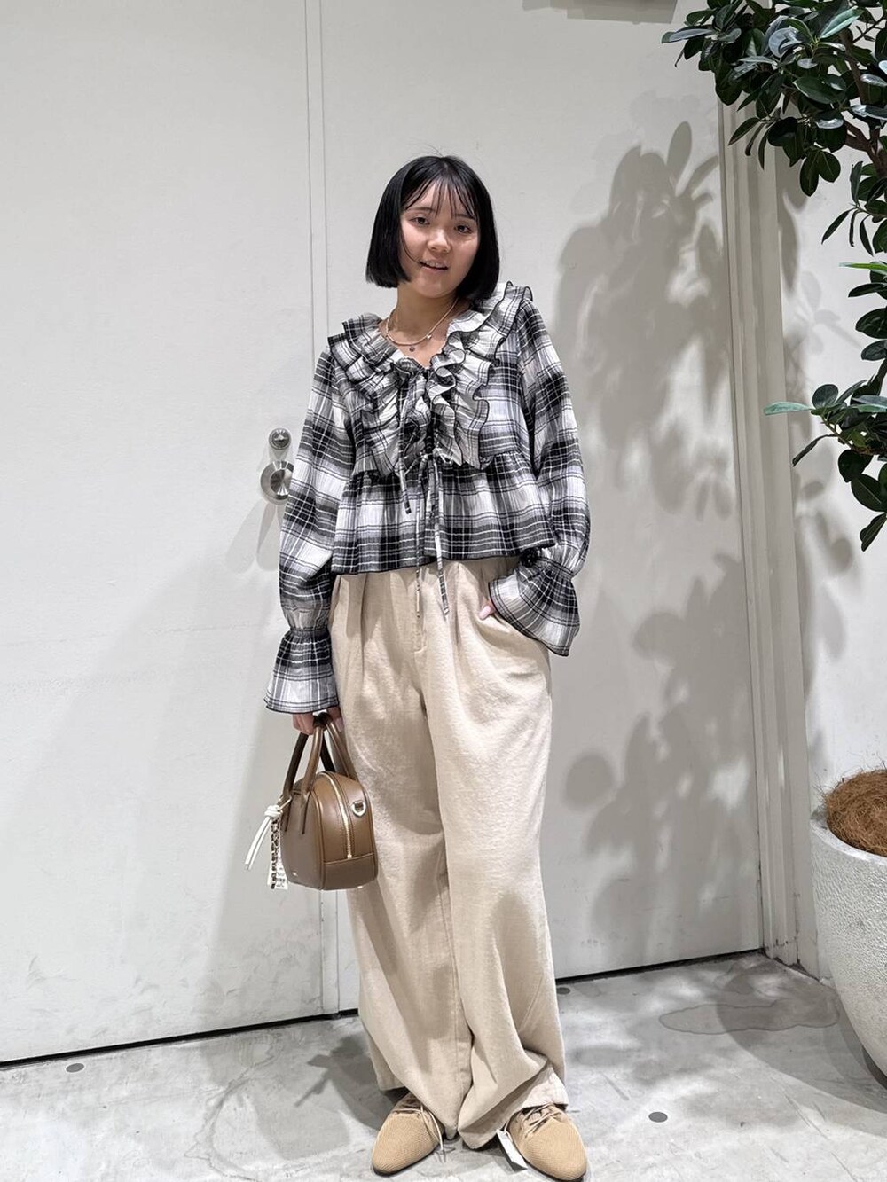 ブラウン系のハンドバッグ、ベージュ系のサンダル、ベージュ系のその他パンツを着用したレディースの春コーディネートの2枚目の写真