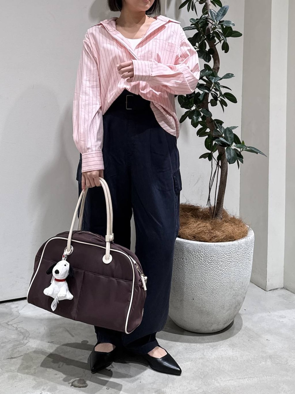 ブラウン系のボストンバッグ、ブラック系のパンプス、ブルー系のカーゴパンツを着用したレディースの春コーディネートの4枚目の写真