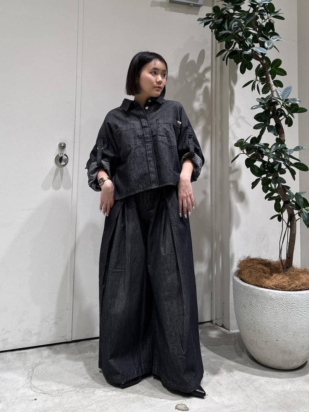 ブラック系のパンプス、ブラック系のシャツ/ブラウス、ブラック系のデニムパンツを着用したレディースの冬コーディネートの2枚目の写真