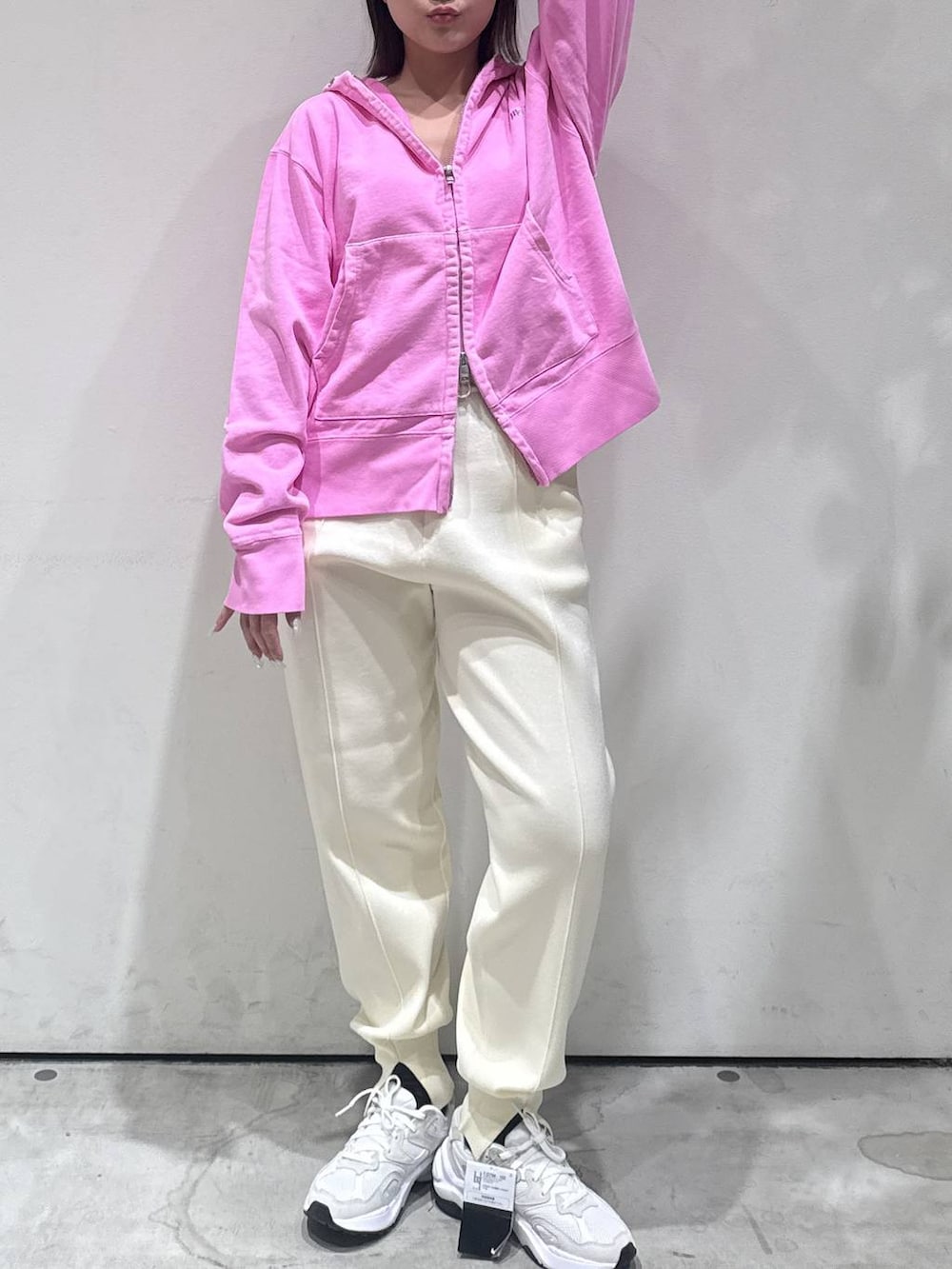 ピンク系のパーカー、ホワイト系のその他パンツを着用したレディースの冬コーディネートの3枚目の写真