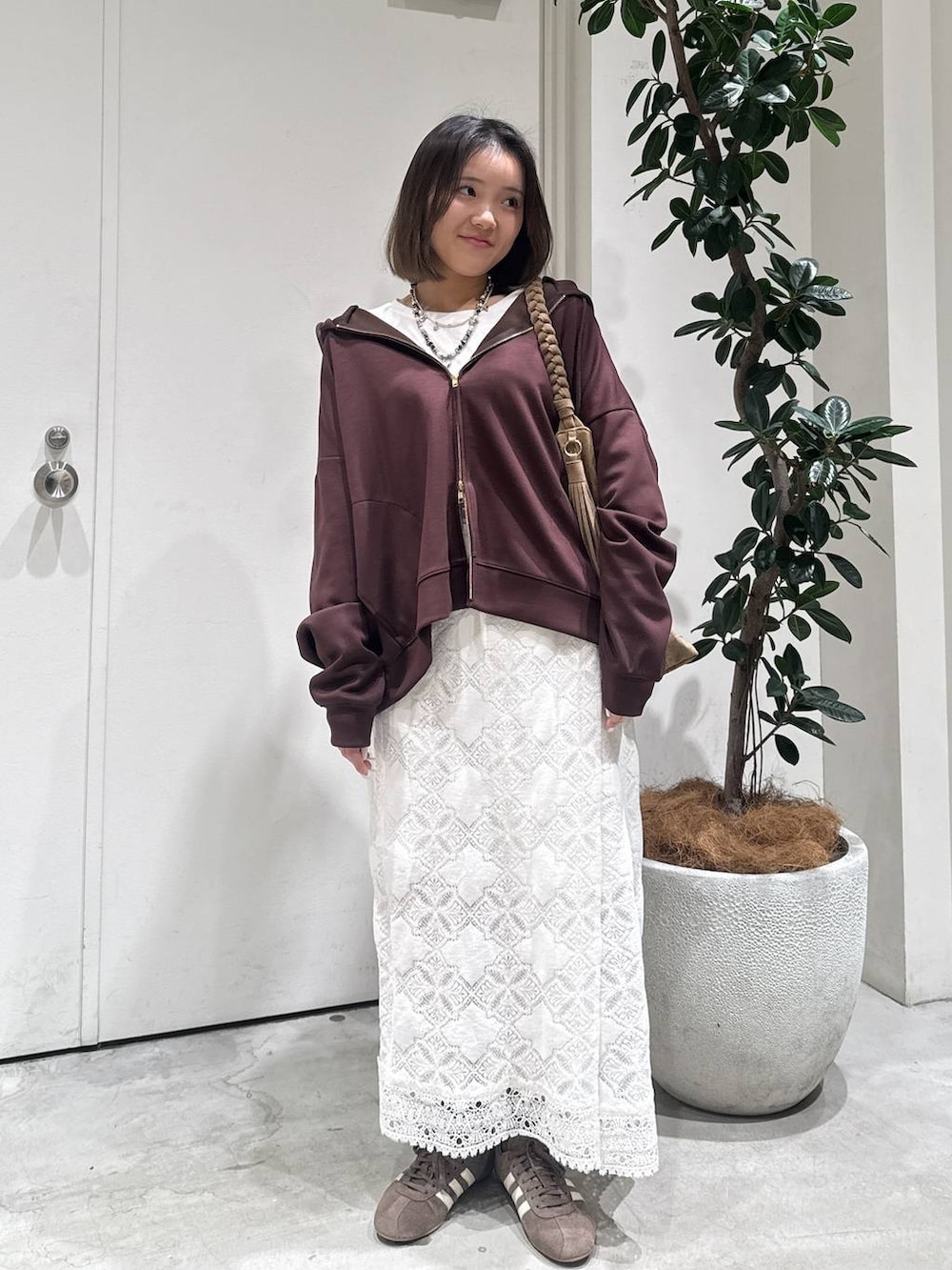 ブラウン系のパーカー、ホワイト系のスカートを着用したレディースの冬コーディネートの3枚目の写真