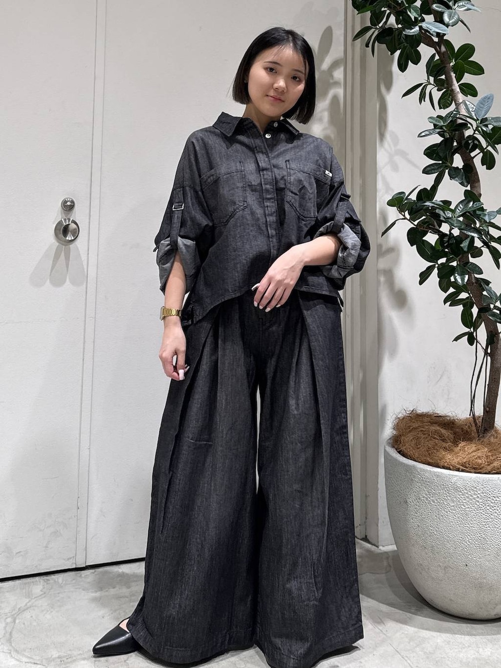 ブラック系のパンプス、ブラック系のシャツ/ブラウス、ブラック系のデニムパンツを着用したレディースの冬コーディネートの3枚目の写真