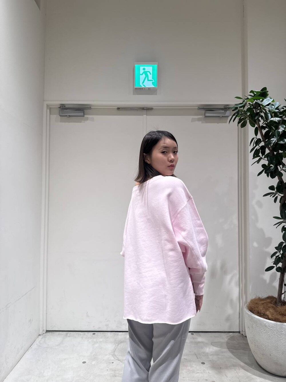 ピンク系のスウェット、グレー系のその他パンツを着用したレディースの冬コーディネートの5枚目の写真