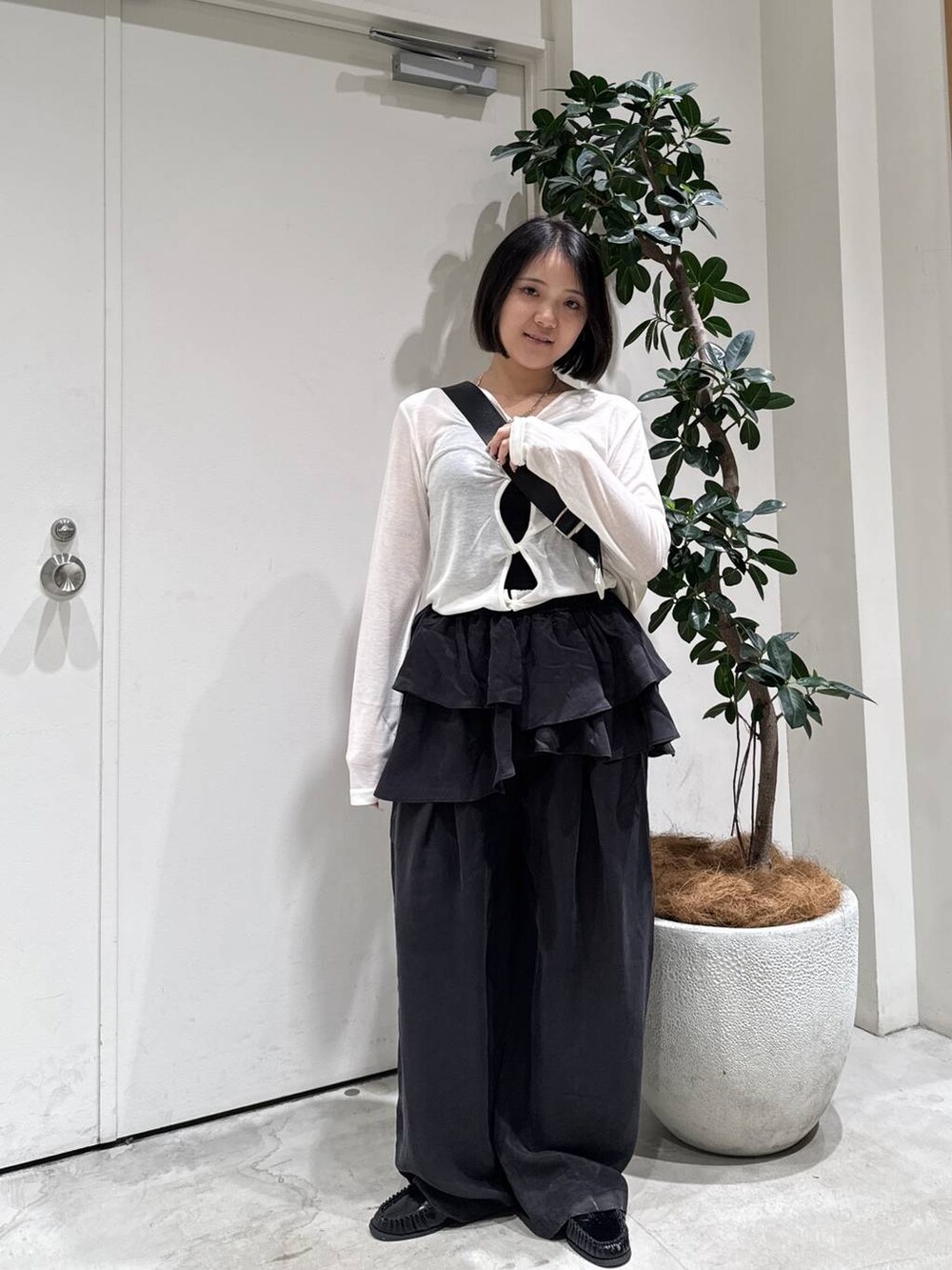 ブラック系のローファー、ホワイト系のショルダーバッグ、ブラック系のその他パンツを着用したレディースの春コーディネートの4枚目の写真