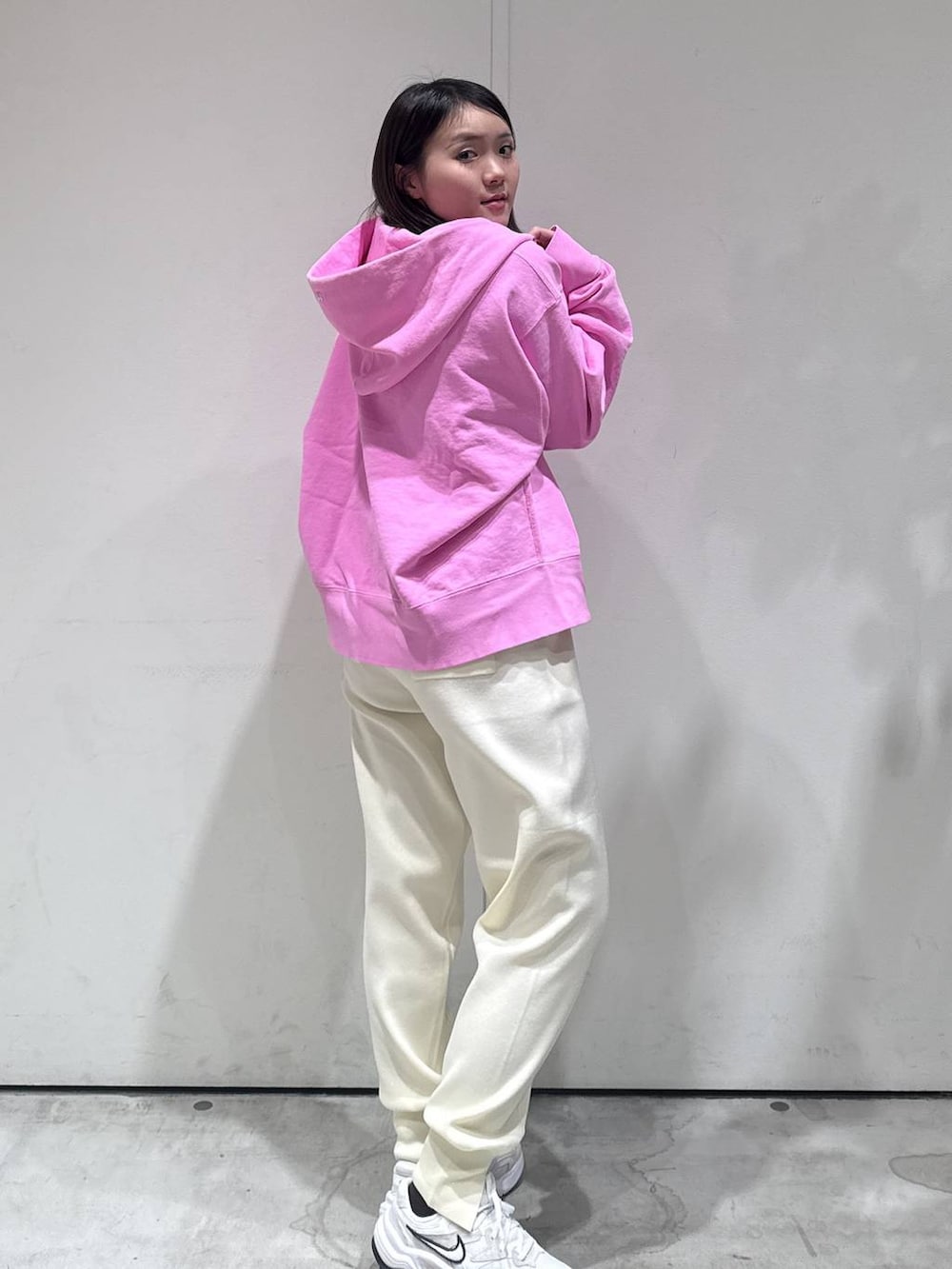 ピンク系のパーカー、ホワイト系のその他パンツを着用したレディースの冬コーディネートの2枚目の写真