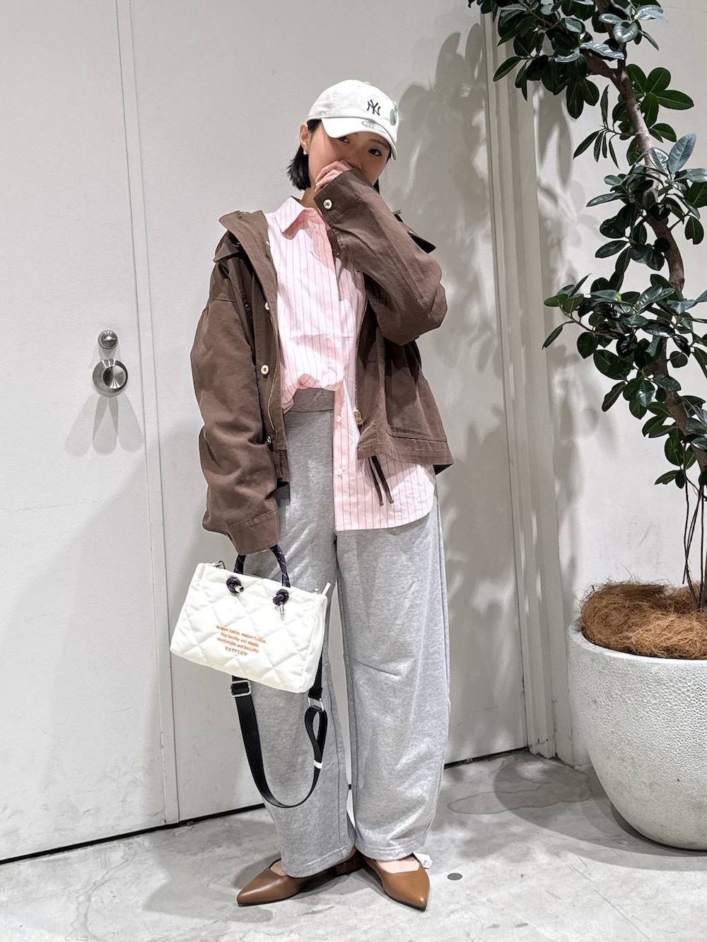 ブラウン系のパンプス、ピンク系のシャツ/ブラウス、グレー系のその他パンツを着用したレディースの春コーディネートの3枚目の写真