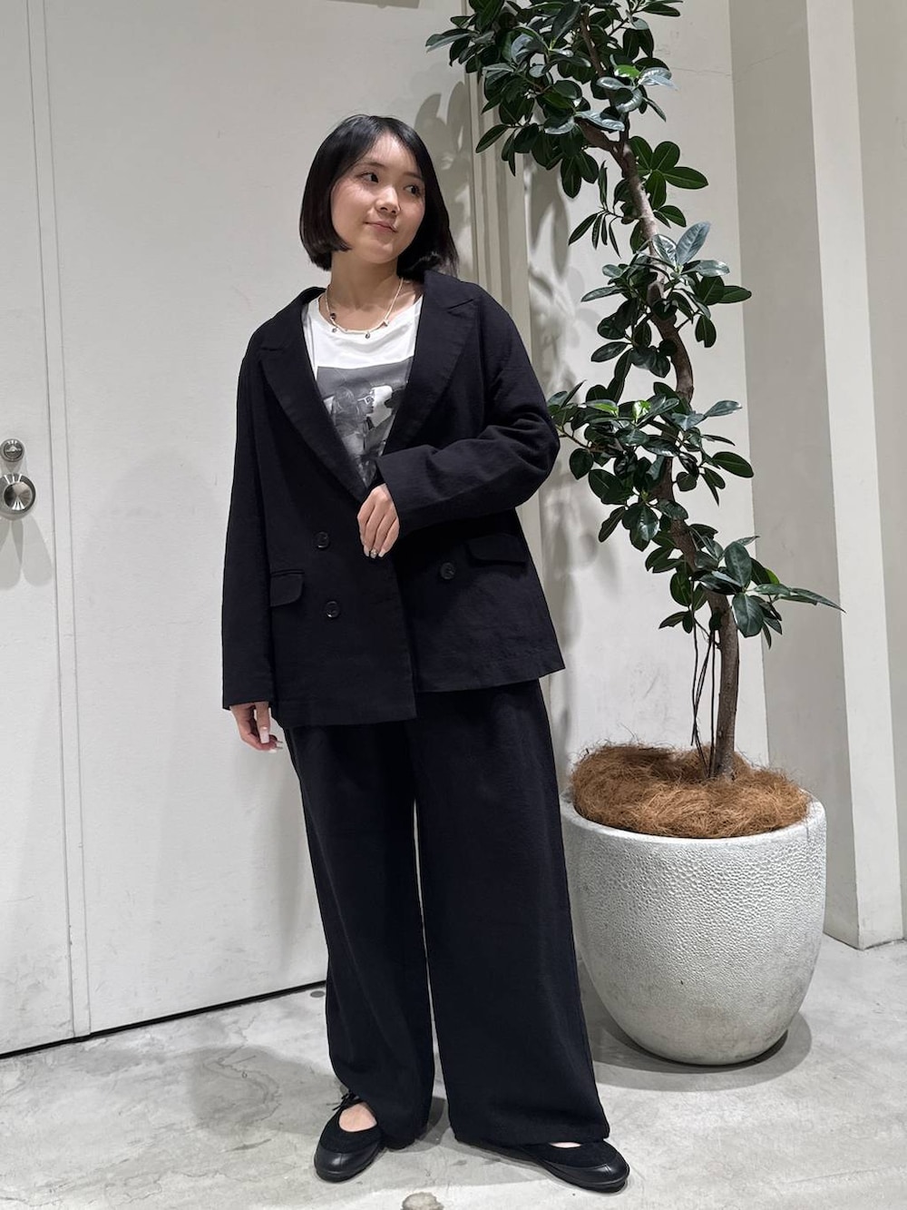 ホワイト系のTシャツ/カットソー、ブラック系のバレエシューズ、ブラック系のテーラードジャケットを着用したレディースの春コーディネートの3枚目の写真