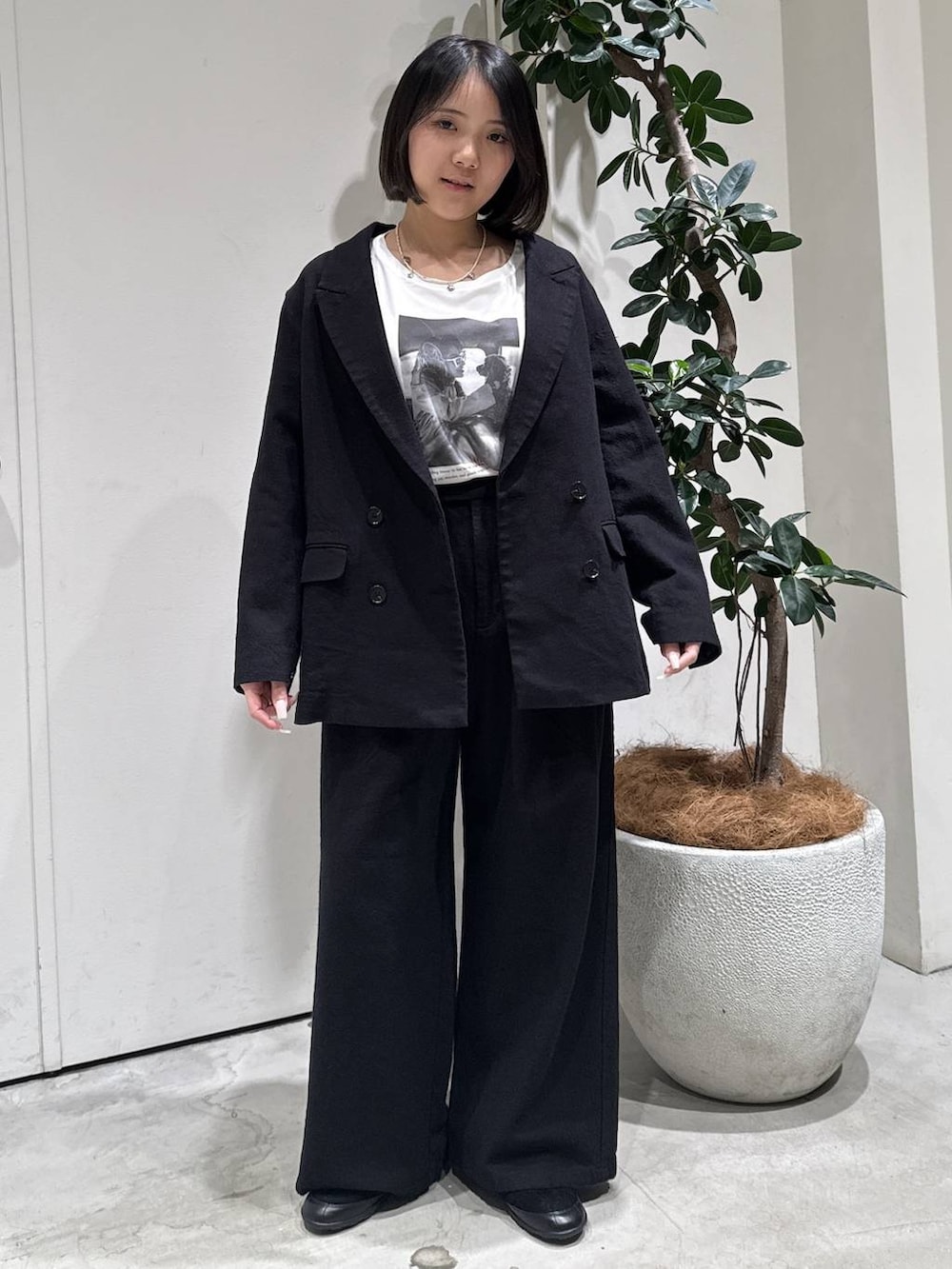 ホワイト系のTシャツ/カットソー、ブラック系のバレエシューズ、ブラック系のテーラードジャケットを着用したレディースの春コーディネートの2枚目の写真