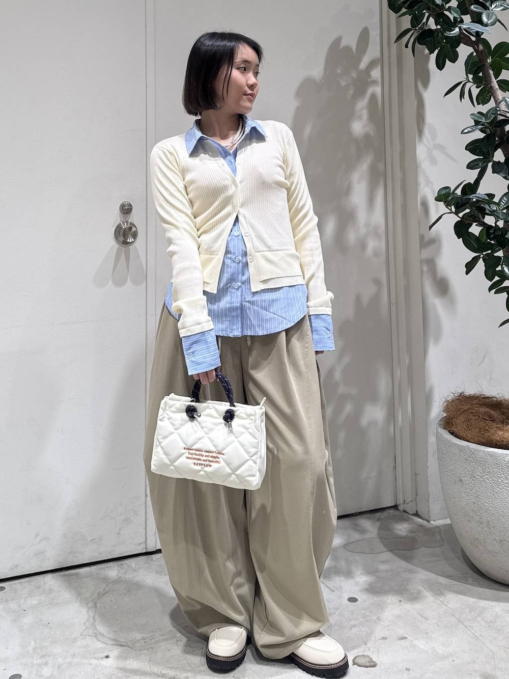 ホワイト系のローファー、ベージュ系のその他パンツ、ホワイト系のショルダーバッグを着用したレディースの冬コーディネートの3枚目の写真