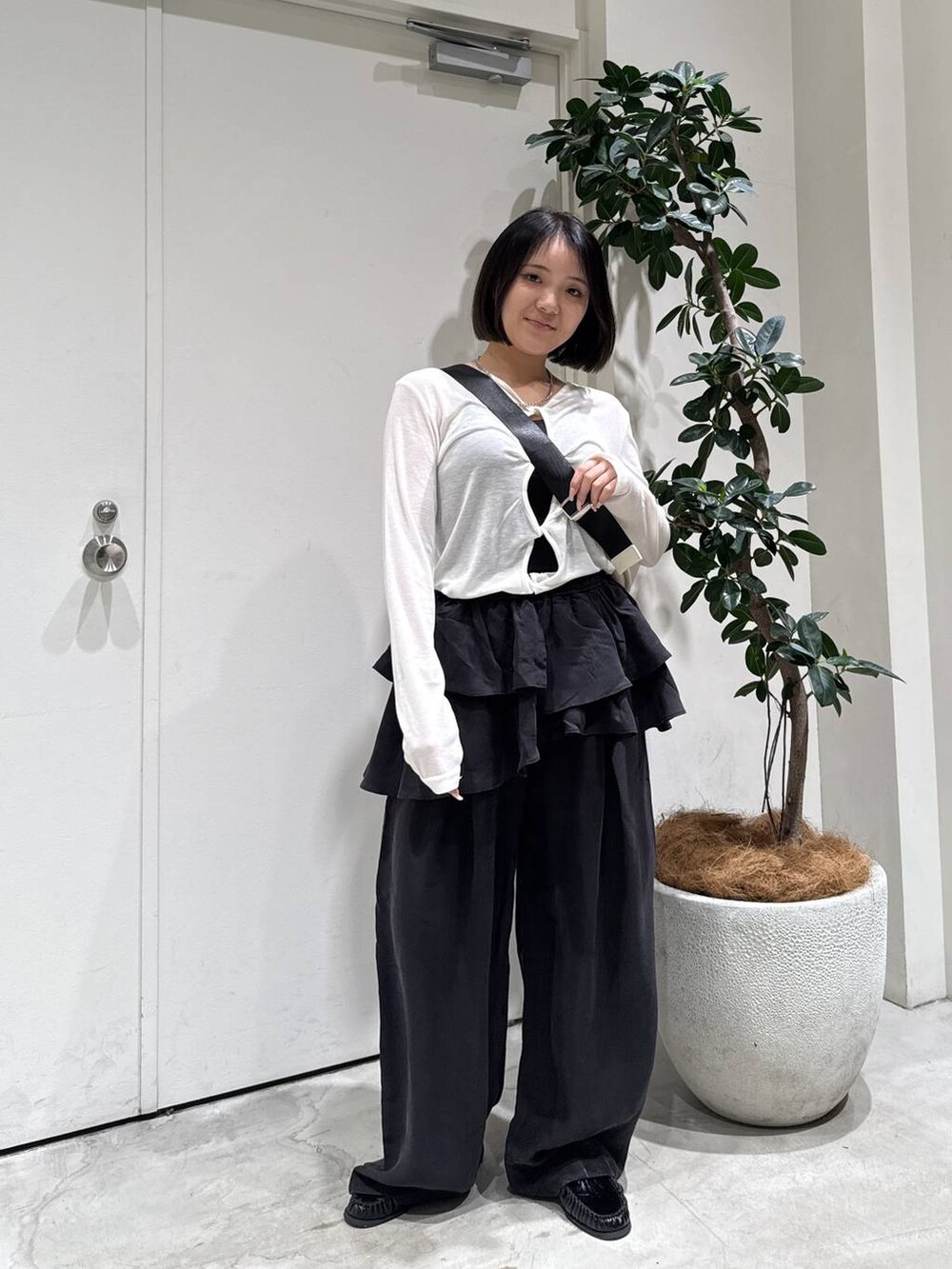 ブラック系のローファー、ホワイト系のショルダーバッグ、ブラック系のその他パンツを着用したレディースの春コーディネートの2枚目の写真