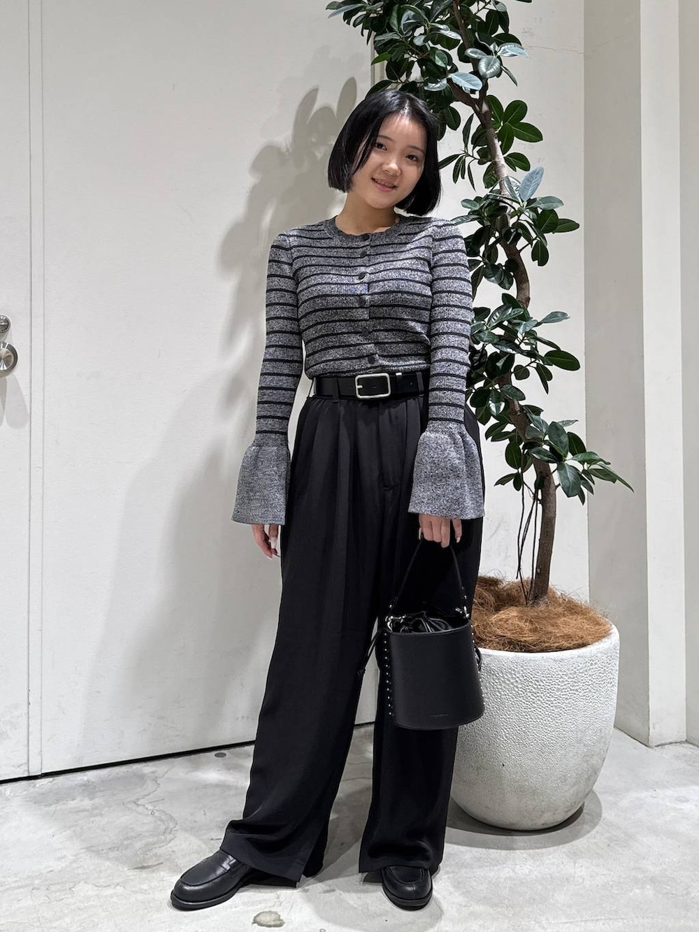 その他のローファー、ブラック系のハンドバッグ、ブラック系のその他パンツを着用したレディースの冬コーディネートの4枚目の写真