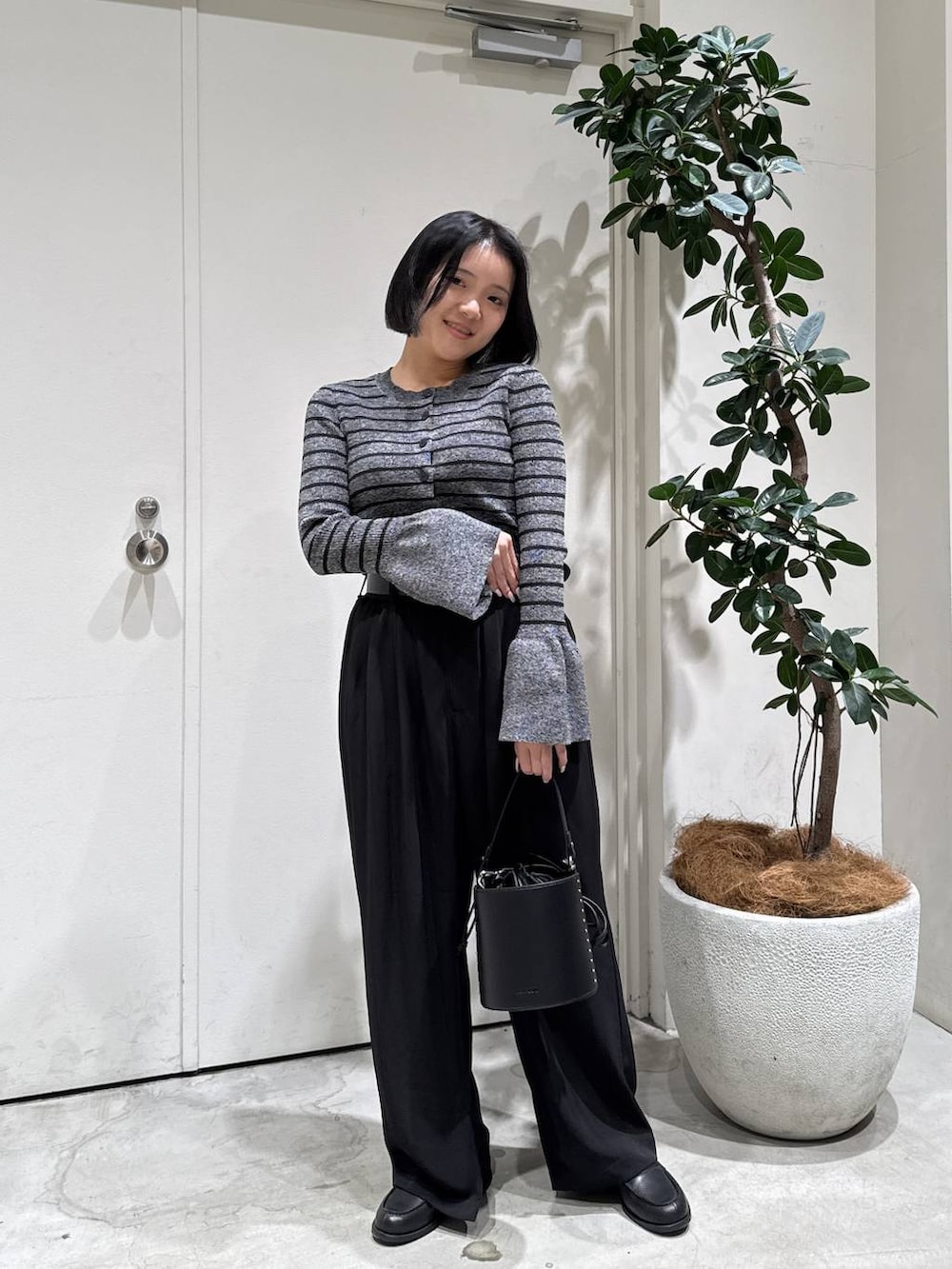 その他のローファー、ブラック系のハンドバッグ、ブラック系のその他パンツを着用したレディースの冬コーディネートの2枚目の写真