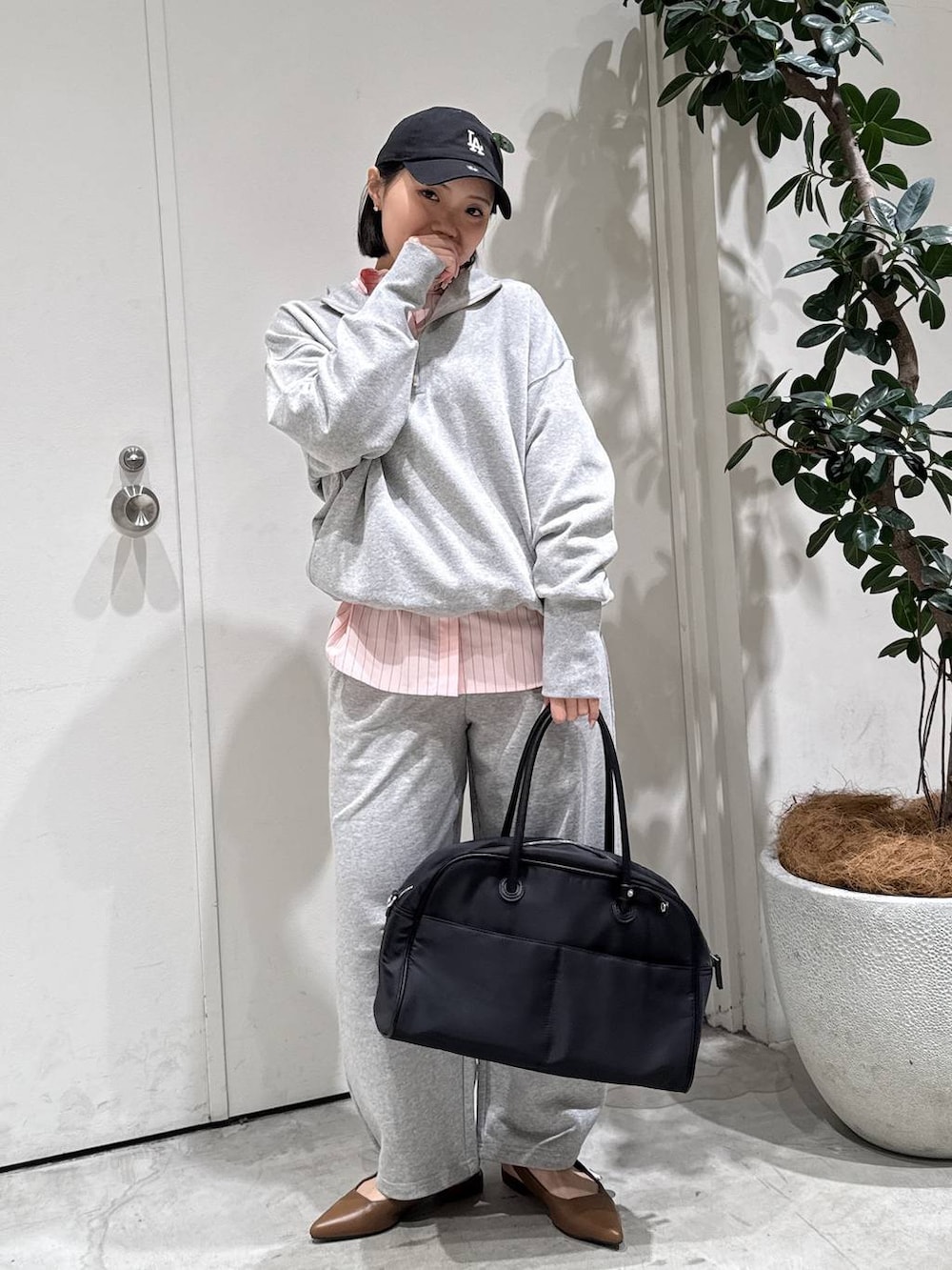 ブラウン系のパンプス、ピンク系のシャツ/ブラウス、グレー系のその他パンツを着用したレディースの春コーディネートの3枚目の写真