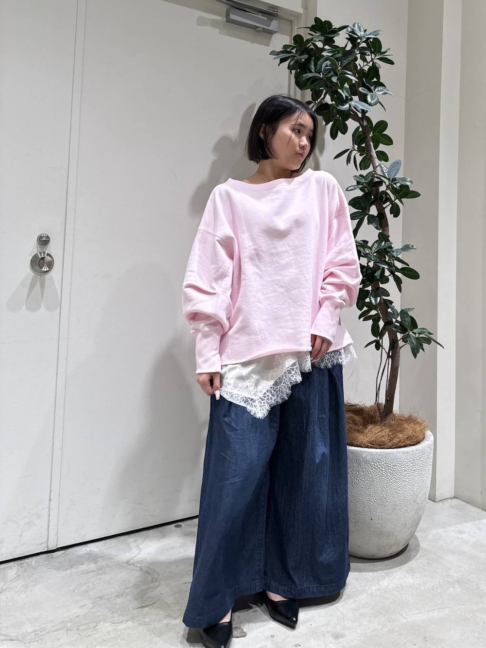 ブラック系のパンプス、ピンク系のスウェット、ベージュ系のキャミソールを着用したレディースの冬コーディネートの4枚目の写真