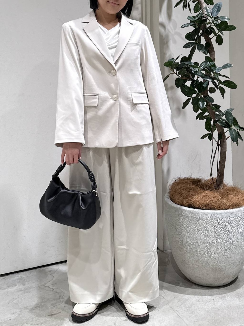 ベージュ系のテーラードジャケット、ベージュ系のスラックス、ブラック系のハンドバッグを着用したレディースの冬コーディネートの3枚目の写真