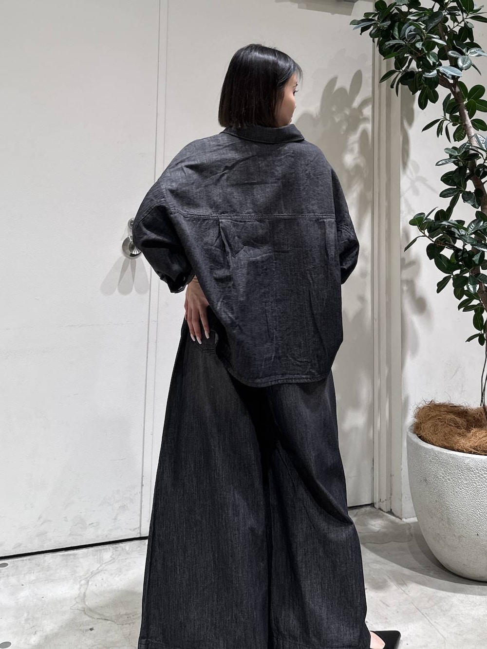 ブラック系のパンプス、ブラック系のシャツ/ブラウス、ブラック系のデニムパンツを着用したレディースの冬コーディネートの4枚目の写真