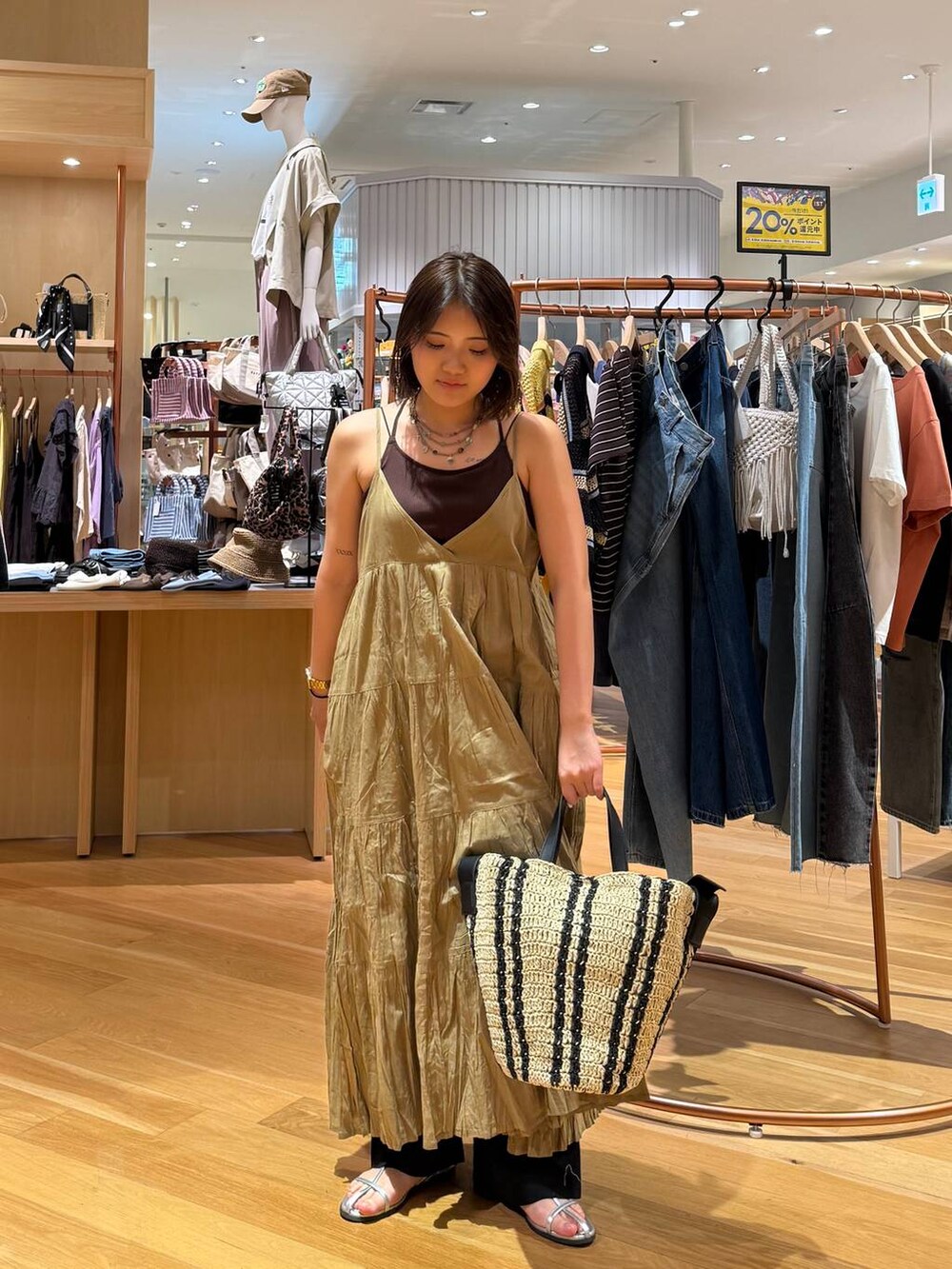 ベージュ系のトートバッグ、グリーン系のワンピース、シルバー系のサンダルを着用したレディースの夏コーディネートの2枚目の写真
