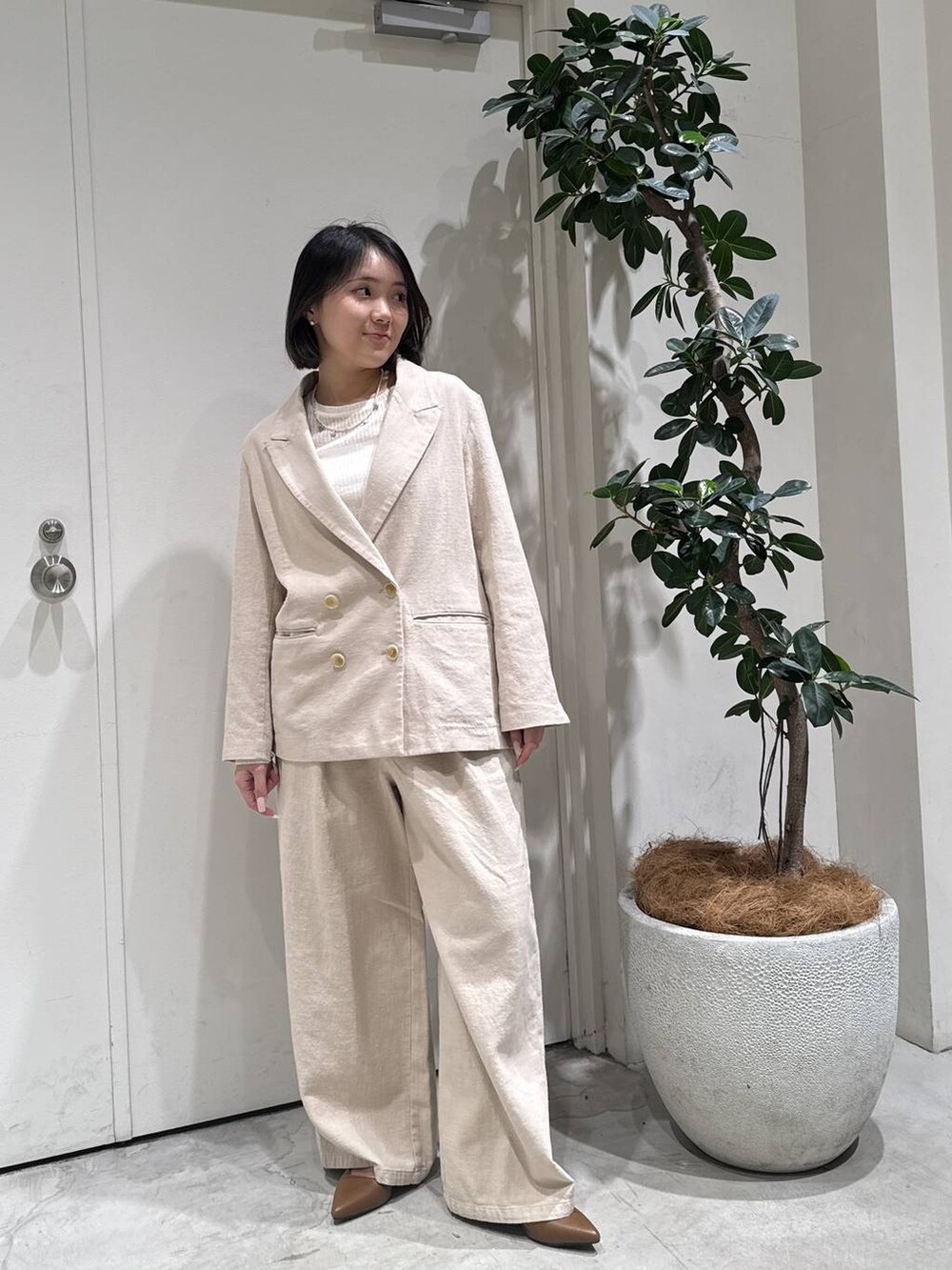 ブラウン系のパンプス、ベージュ系のテーラードジャケット、ベージュ系のその他パンツを着用したレディースの春コーディネートの2枚目の写真