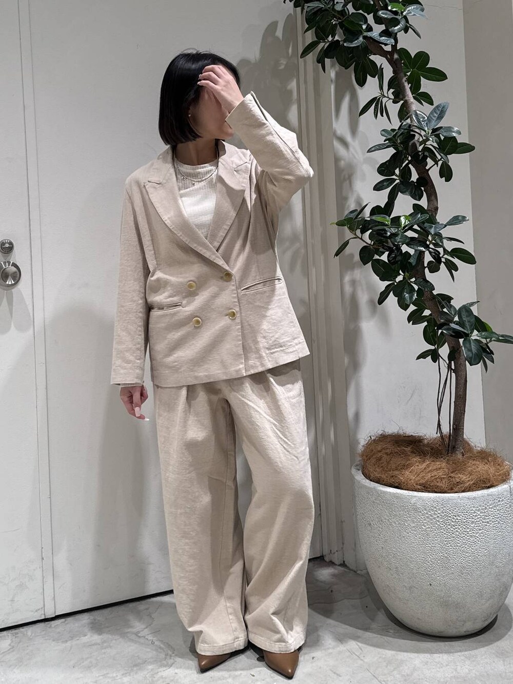 ブラウン系のパンプス、ベージュ系のテーラードジャケット、ベージュ系のその他パンツを着用したレディースの春コーディネートの3枚目の写真