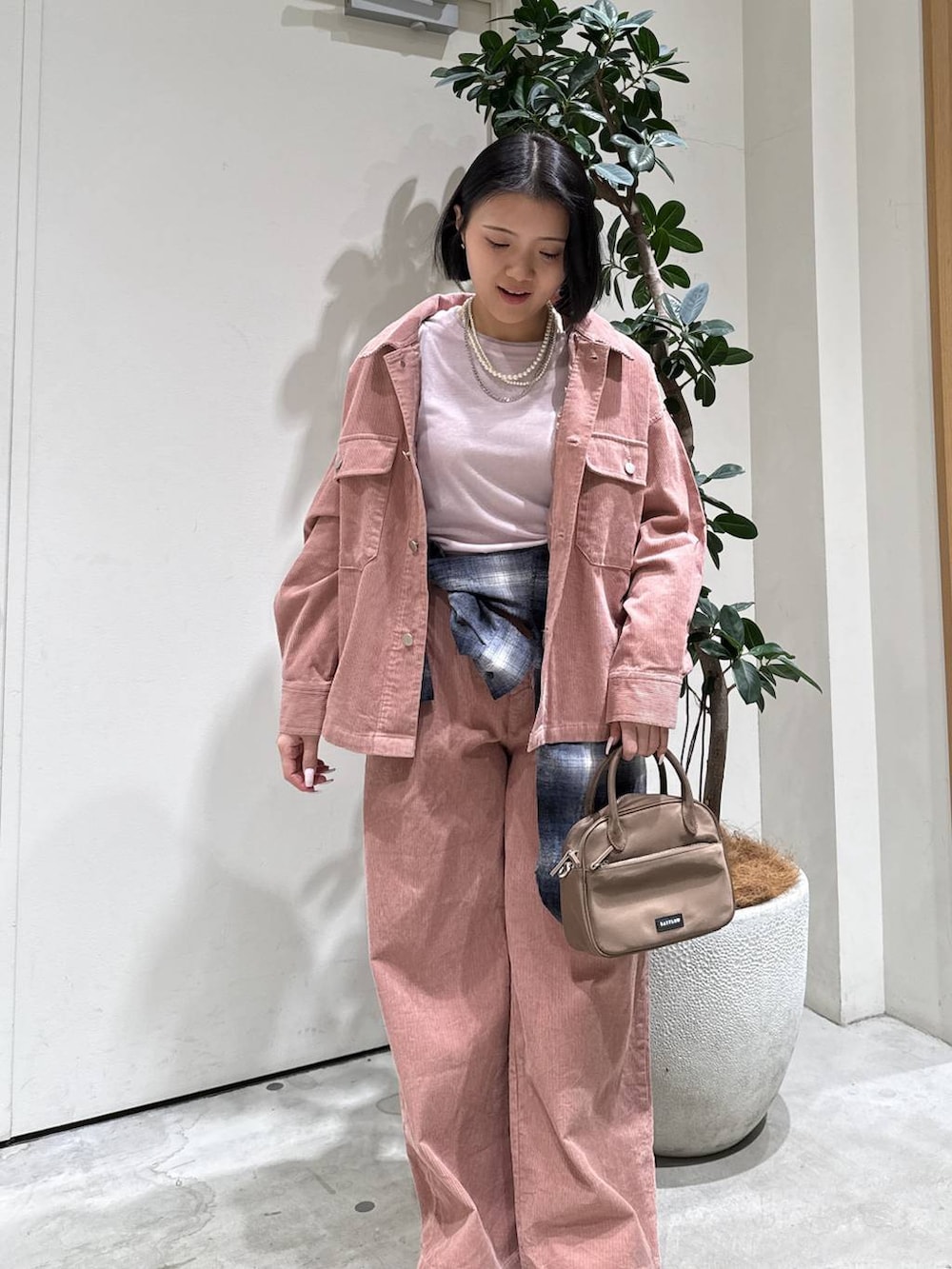 ピンク系のハンドバッグ、ブラック系のシャツ/ブラウス、ピンク系のブルゾンを着用したレディースの冬コーディネートの3枚目の写真