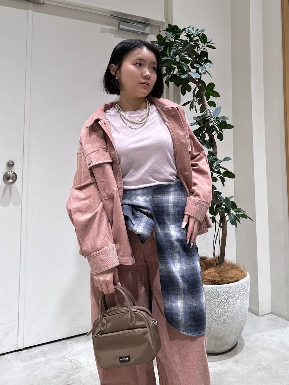 ピンク系のハンドバッグ、ブラック系のシャツ/ブラウス、ピンク系のブルゾンを着用したレディースの冬コーディネートの2枚目の写真