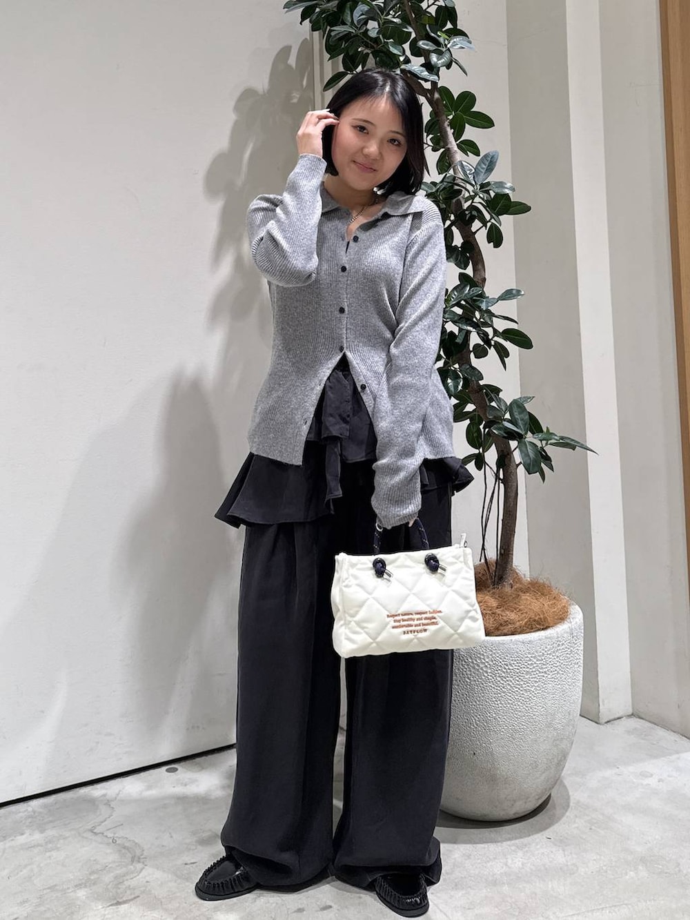 ブラック系のローファー、グレー系のカーディガン/ボレロ、ホワイト系のショルダーバッグを着用したレディースの春コーディネートの3枚目の写真