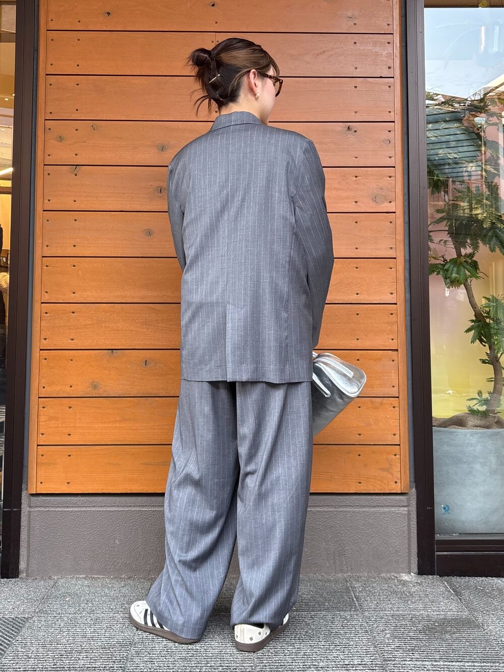 グレー系のテーラードジャケット、グレー系のスラックス、ホワイト系のTシャツ/カットソーを着用したレディースの春コーディネートの2枚目の写真