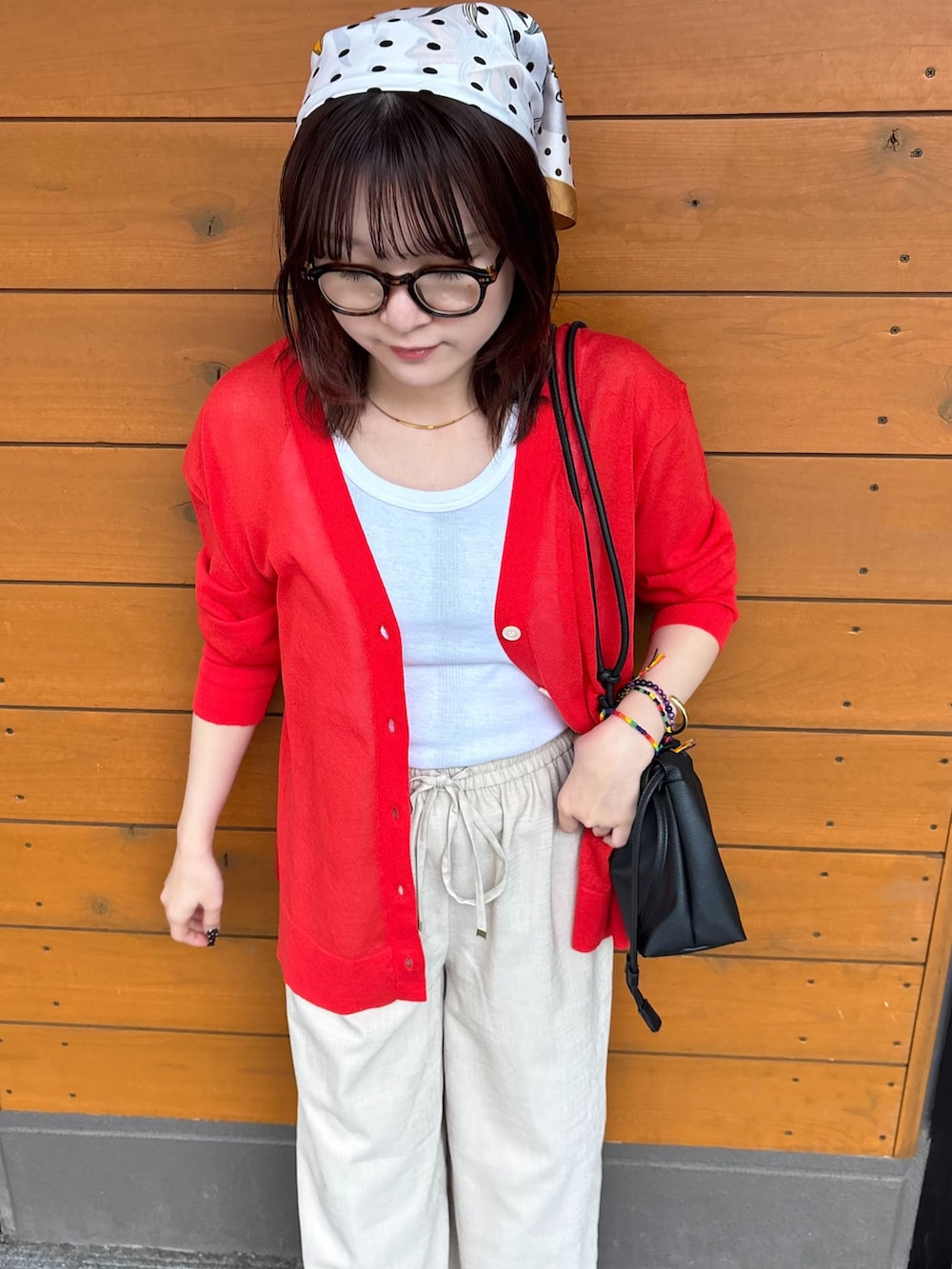 ベージュ系のその他パンツ、ホワイト系のTシャツ/カットソー、レッド系のカーディガン/ボレロを着用したレディースの春コーディネートの3枚目の写真