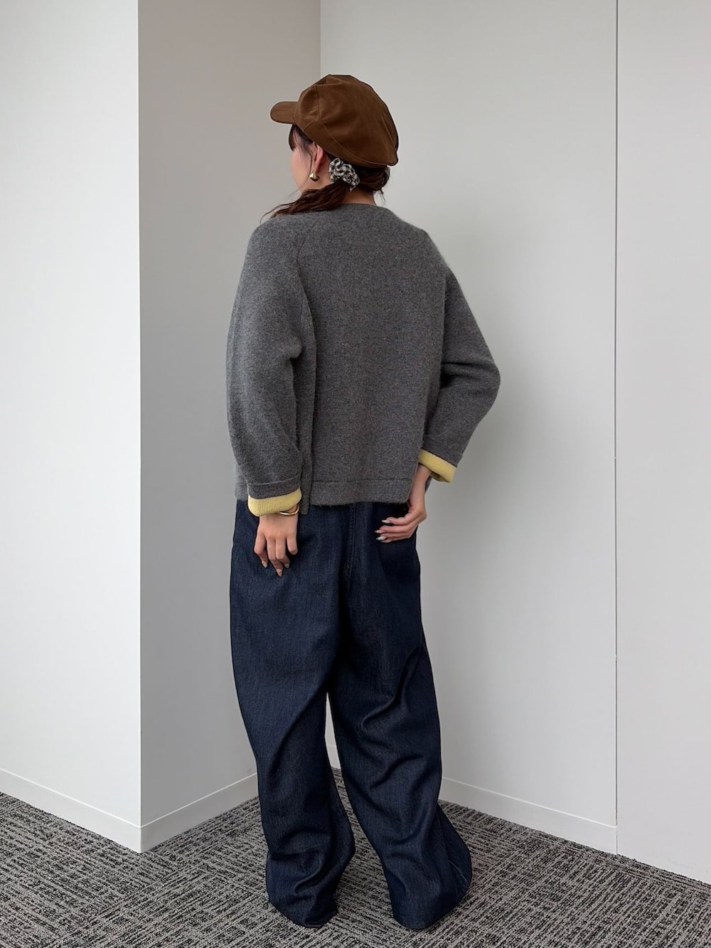 ブルー系のデニムパンツ、ホワイト系のTシャツ/カットソー、グレー系のカーディガン/ボレロを着用したレディースの秋コーディネートの2枚目の写真