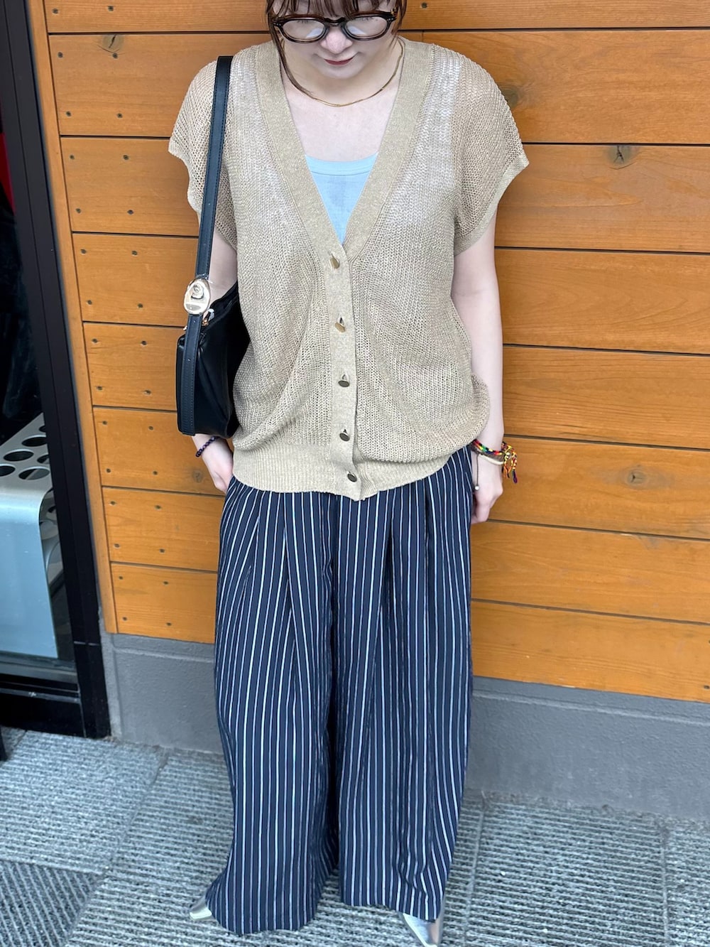 ブルー系のつなぎ/オールインワン、ホワイト系のTシャツ/カットソー、ベージュ系のベストを着用したレディースの春コーディネートの3枚目の写真