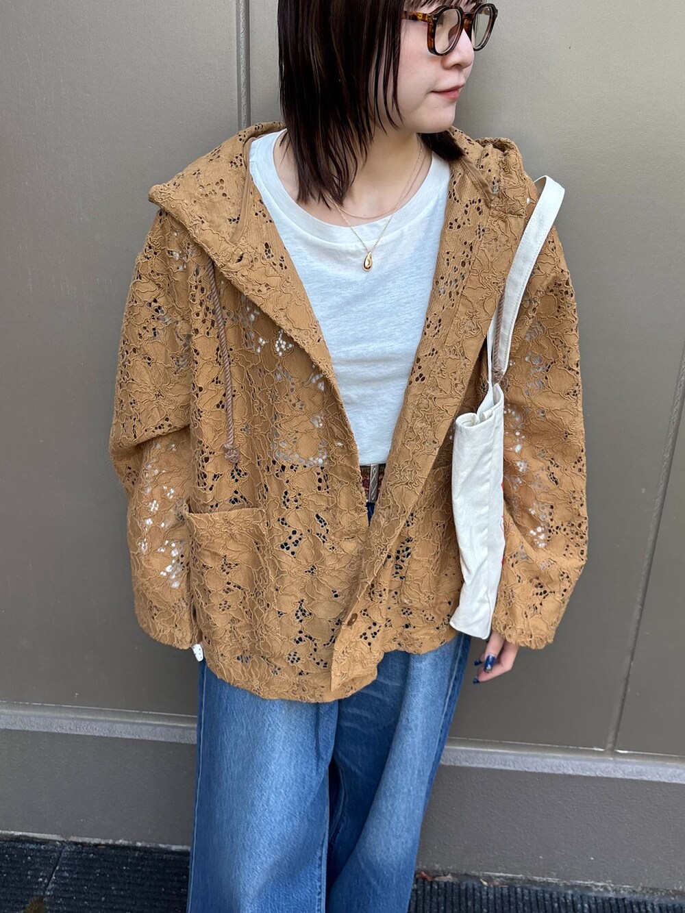 ブルー系のデニムパンツ、イエロー系のシャツ/ブラウス、ホワイト系のTシャツ/カットソーを着用したレディースの春コーディネートの5枚目の写真