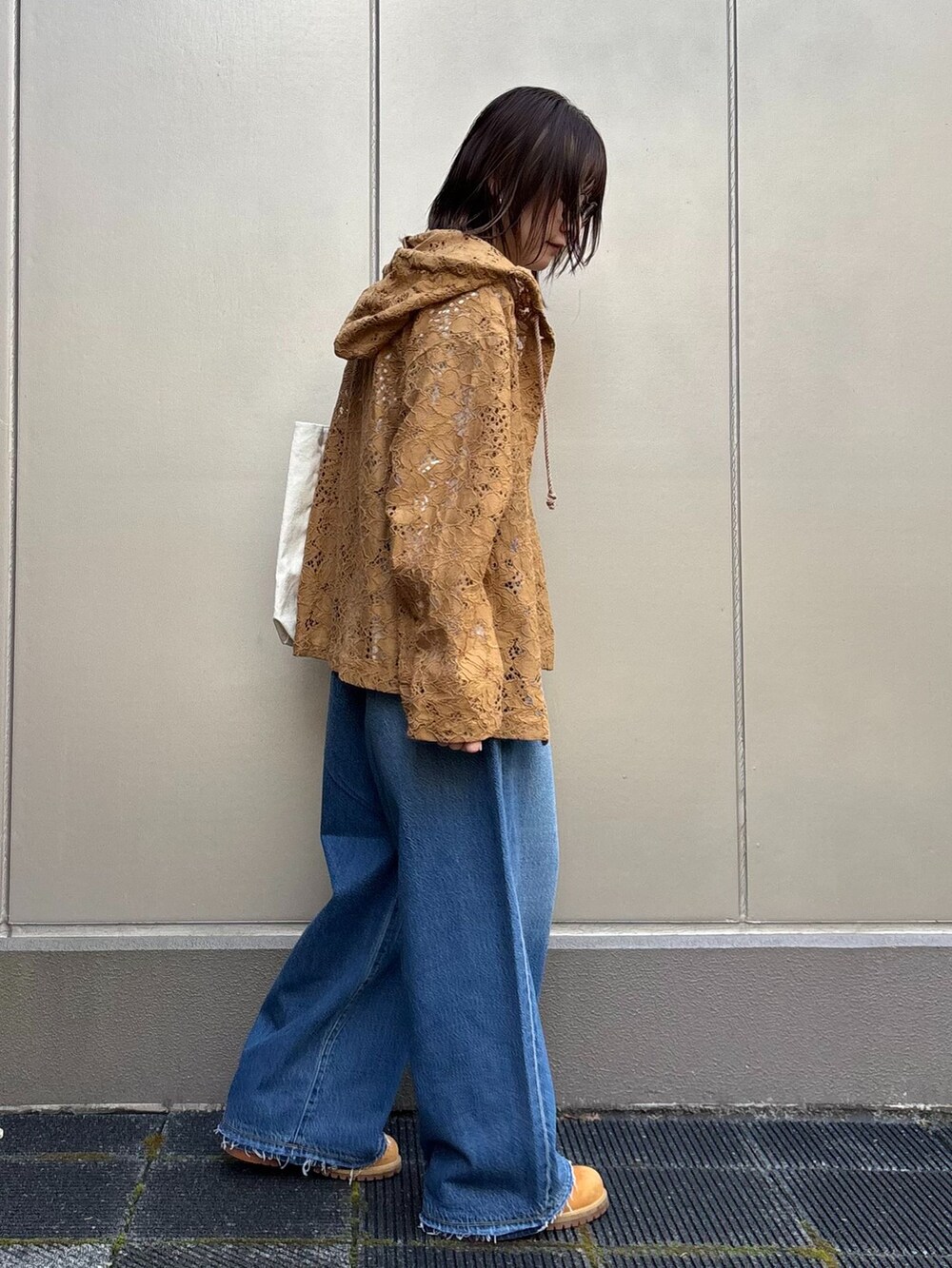 ブルー系のデニムパンツ、イエロー系のシャツ/ブラウス、ホワイト系のTシャツ/カットソーを着用したレディースの春コーディネートの3枚目の写真
