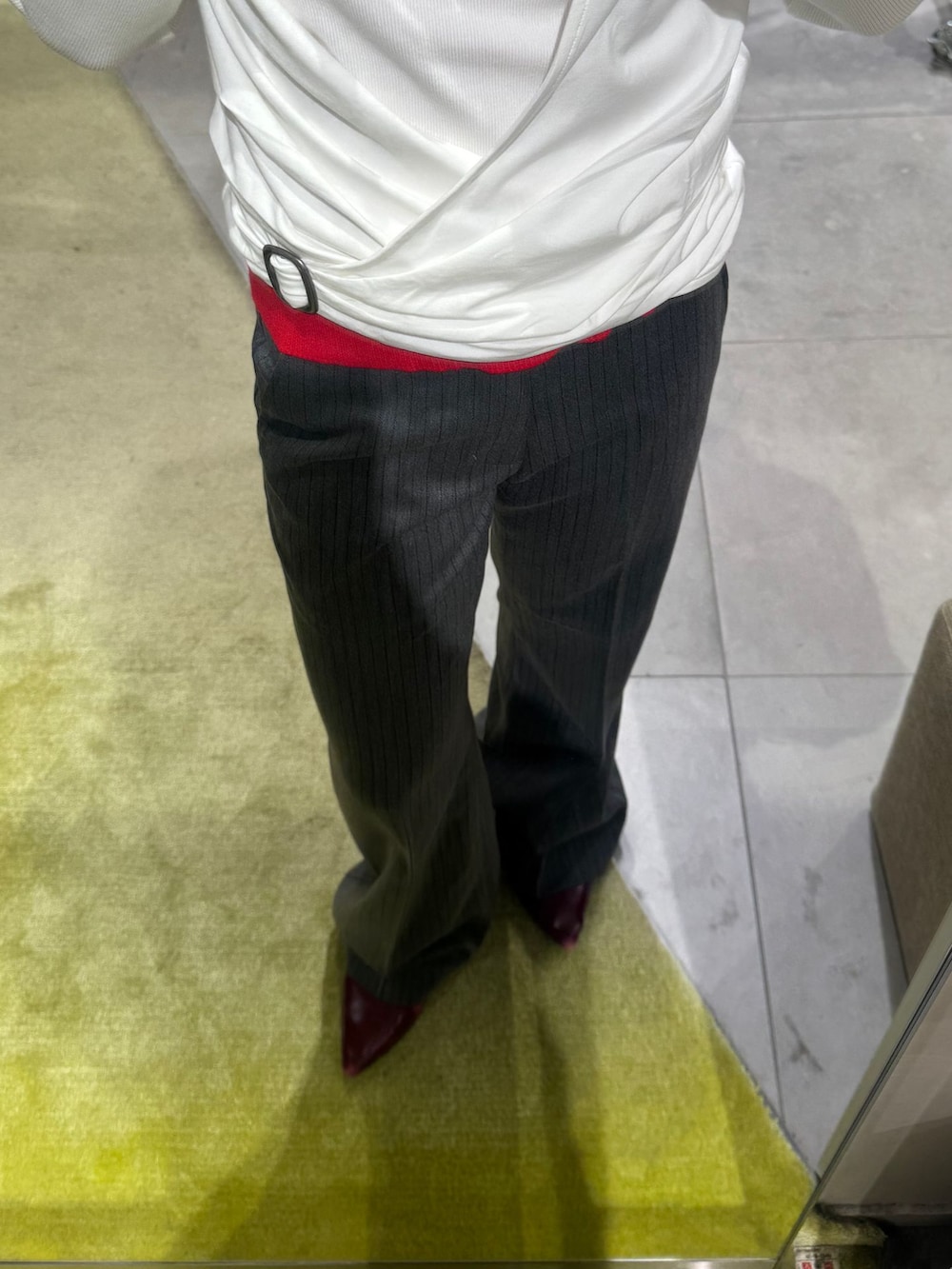 グレー系のスラックス、ホワイト系のTシャツ/カットソー、ブラック系のキャップを着用したレディースの秋コーディネートの2枚目の写真