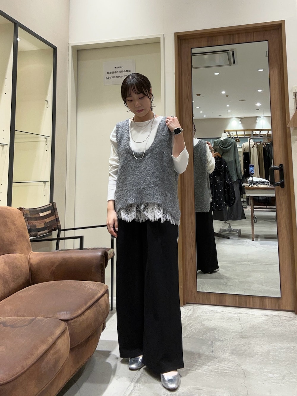 ブラック系のスラックス、グレー系のベスト、ホワイト系のTシャツ/カットソーを着用したレディースの秋コーディネートの2枚目の写真