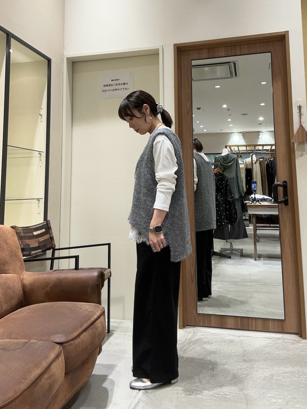 ブラック系のスラックス、グレー系のベスト、ホワイト系のTシャツ/カットソーを着用したレディースの秋コーディネートの3枚目の写真