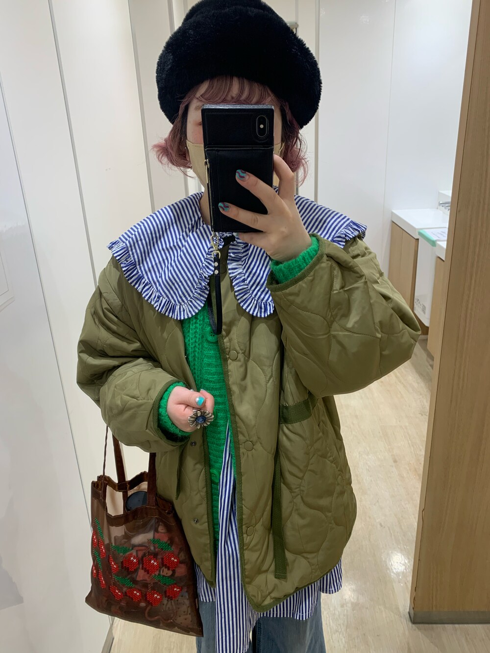 グリーン系のカーディガン/ボレロ、ブルー系のシャツ/ブラウス、ブラック系のハットを着用したレディースの冬コーディネートの2枚目の写真