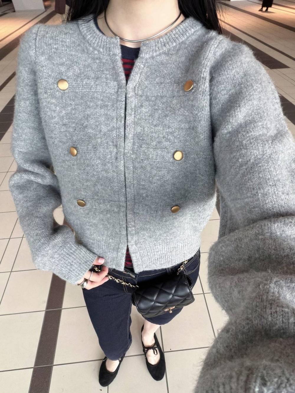 グレー系のノーカラージャケットを着用したレディースの秋コーディネートの3枚目の写真