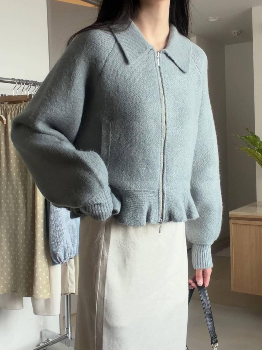 ホワイト系のスカート、ブラック系のショルダーバッグ、グリーン系のブルゾンを着用したレディースの冬コーディネートの7枚目の写真