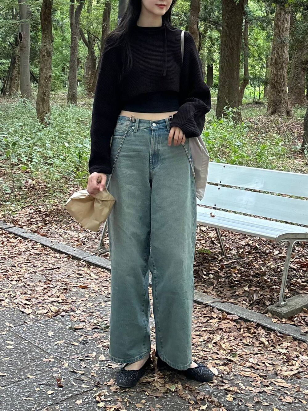 ブラック系のTシャツ/カットソー、ブルー系のデニムパンツ、ブラック系のニット/セーターを着用したレディースの秋コーディネートの2枚目の写真